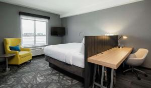 ウィニペグにあるHilton Garden Inn Winnipeg Southのベッド、デスク、椅子が備わるホテルルームです。