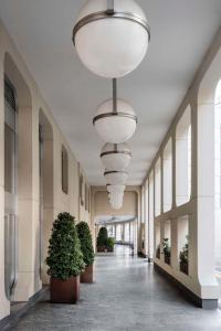 un couloir avec des plantes en pot et des lumières dans un bâtiment dans l'établissement Hilton Garden Inn Padova City Centre, à Padoue