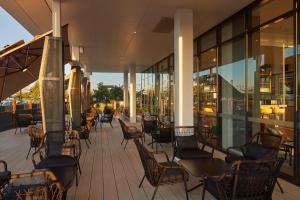 a patio with chairs and tables on a building at Hilton Garden Inn Busselton in Busselton