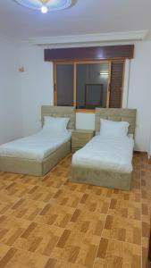 2 Betten in einem Zimmer mit Holzböden in der Unterkunft شقه فخمه مفروشه بالكامل في اربد in Irbid