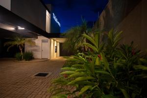 a building with plants in a courtyard at night at THÁI MOTEL in Mogi Guaçu