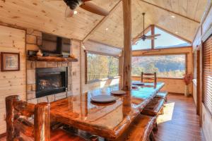a dining room with a wooden table and a fireplace at Parkview Lodge In Gatlinburg in Gatlinburg