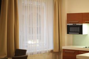 a kitchen with a window with curtains and a chair at Home Sweet Home - Stephansdom II in Vienna
