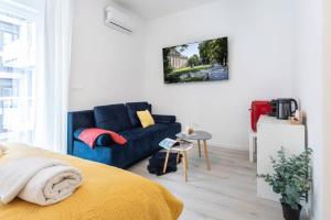 ein Wohnzimmer mit einem blauen Sofa und einem Tisch in der Unterkunft Lux Nest Extra City Apartment URBAN STAY in Zagreb