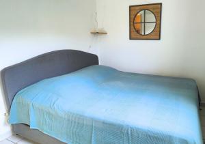 1 cama con manta azul y espejo en la pared en Mazet - à 300m de la plage / Terrasse / Wifi / La Conciergerie Varoise, en La Londe-les-Maures