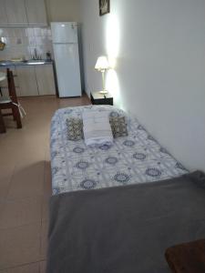 a bed in a room with a table with a lamp at Duplex Playa Unión in Playa Unión