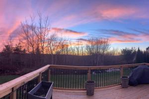 a wooden deck with a sunset in the background at Beautiful and Peaceful Home in Halifax