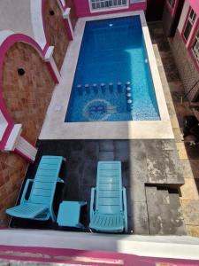 two blue chairs and a swimming pool at Hotel Capri Playa a una calle de la Playa Regatas in Veracruz