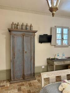 a large wooden cabinet in a room with a table at Casale San Giorgio in Luco di Mugello
