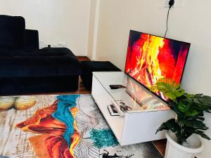 a living room with a flat screen tv on a table at Adjana’s Cozy apartment in Nairobi
