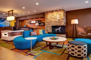 a living room with blue furniture and a fireplace at Fairfield Inn & Suites Lincoln Crete in Crete