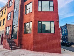 - un bâtiment en briques rouges avec des fenêtres donnant sur une rue dans l'établissement The London, à Philadelphie