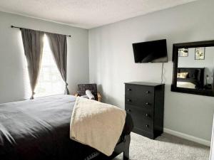 um quarto com uma cama, uma cómoda e um espelho em Queen Suite Home Theater WiFi 2 em Morrow