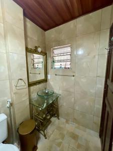 a bathroom with a glass sink and a mirror at Espaço Vitória Imperial in Guapimirim +26 photos