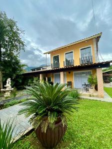 a house with a palm tree in front of it at Espaço Vitória Imperial in Guapimirim