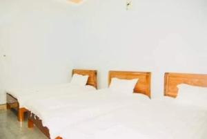 a row of white beds in a bedroom at Nhà nghỉ Thiên Phúc in Mộc Châu