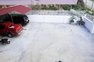 a parking lot with a red jeep parked under an umbrella at Nhà nghỉ Thiên Phúc in Mộc Châu