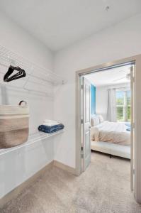 Cette chambre blanche comprend un lit et un miroir. dans l'établissement Luxury Stylish Apt in Historic Ybor City, à Tampa