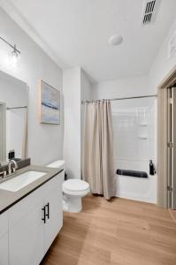 a white bathroom with a toilet and a sink at Luxury Stylish Apt in Historic Ybor City in Tampa