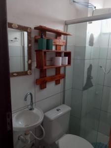 a bathroom with a toilet and a sink and a mirror at Apto bem localizado est de Ribamar ao lado do shopping in São-José-do-Ribamar
