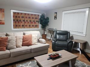 East End Suite في Eastern Passage: غرفة معيشة مع أريكة وكرسي