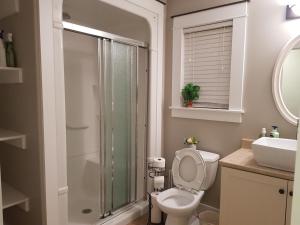 a bathroom with a toilet and a shower and a sink at East End Suite in Eastern Passage