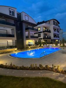a large swimming pool in front of some buildings at Belek’de 2+1 klimalı havuzlu lüks daire in Belek