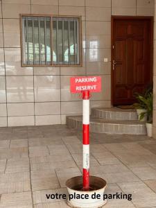 a red and white sign in front of a building at Chez Maëlys in Douala