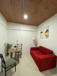 sala de estar con sofá rojo y mesa en The Sloth Retreat & Studio Fortuna en Fortuna