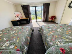 a hotel room with two beds and a window at Luxury Modern 3-BDR Oasis in Kumeu