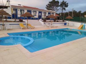 een zwembad op een resort met stoelen en parasols bij Monte Antonio Domingos in Melides