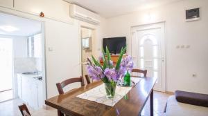 a vase of flowers on a wooden table in a living room at Holiday house with a parking space Zrnovnica, Split - 22688 in Žrnovnica