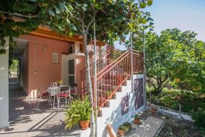 a house with a staircase and a table on a patio at Holiday house with a parking space Zrnovnica, Split - 22688 in Žrnovnica