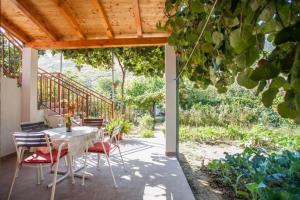 a patio with a table and chairs on a porch at Holiday house with a parking space Zrnovnica, Split - 22688 in Žrnovnica +7 photos