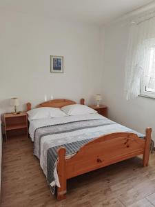 ein Schlafzimmer mit einem Holzbett mit zwei Nachttischen in der Unterkunft Holiday house with a parking space Bibinje, Zadar - 22783 in Bibinje