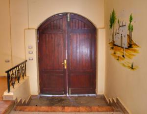 a large wooden door in a building with stairs at Hadouta Masreya Nubian Guest House in Aswan