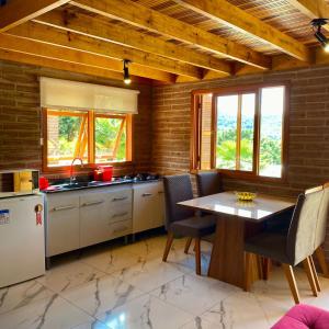 cocina con mesa y sillas en una habitación en Villetta Gramado Siena en Gramado