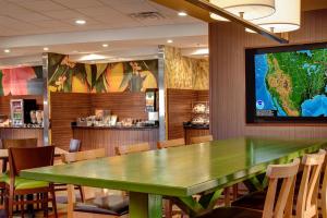 a conference room with a green table and a tv at Fairfield Inn & Suites by Marriott St. Paul Northeast in Vadnais Heights