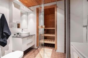 a bathroom with a shower and a toilet and a sink at City flat with a sauna & balcony in Helsinki