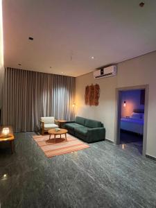 un soggiorno con divano verde e letto di Timber suites تمبر سويتس a Riyad