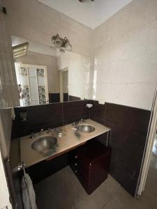 a bathroom with two sinks and a large mirror at Villa Tequila-Casa Frida in Alta Gracia +18 photos