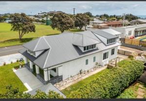 an aerial view of a white house with a roof at Giggly Nest in New Plymouth