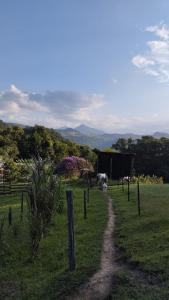 een zandpad in een veld met dieren in de verte bij Sítio Vó Leonidia - Turismo Rural in Ilha Grande