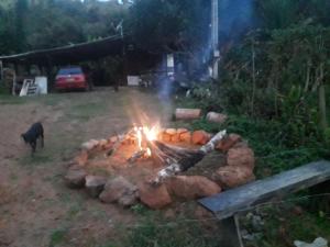een vuurplaats in een tuin 's nachts met een hond bij Sítio Vó Leonidia - Turismo Rural in Ilha Grande