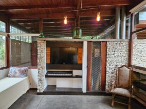 an outdoor living room with a fireplace and a tv at Casadebosq in Mar del Plata