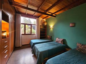 two beds in a room with green walls and a window at Casadebosq in Mar del Plata
