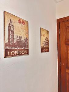 two pictures of london on a white wall at Chez Maëlys in Douala