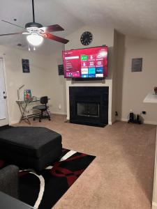 uma sala de estar com uma televisão de ecrã plano por cima de uma lareira em Haven Away From Home Ideal For Long Term Stays em Fayetteville