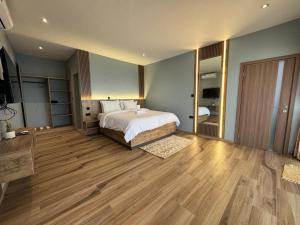 a large bedroom with a bed and a wooden floor at Oceanview Cabins in Nyanyanu