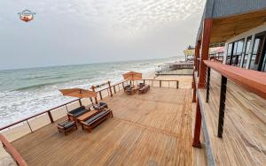 a deck with chairs and umbrellas on the beach at Oceanview Cabins in Nyanyanu